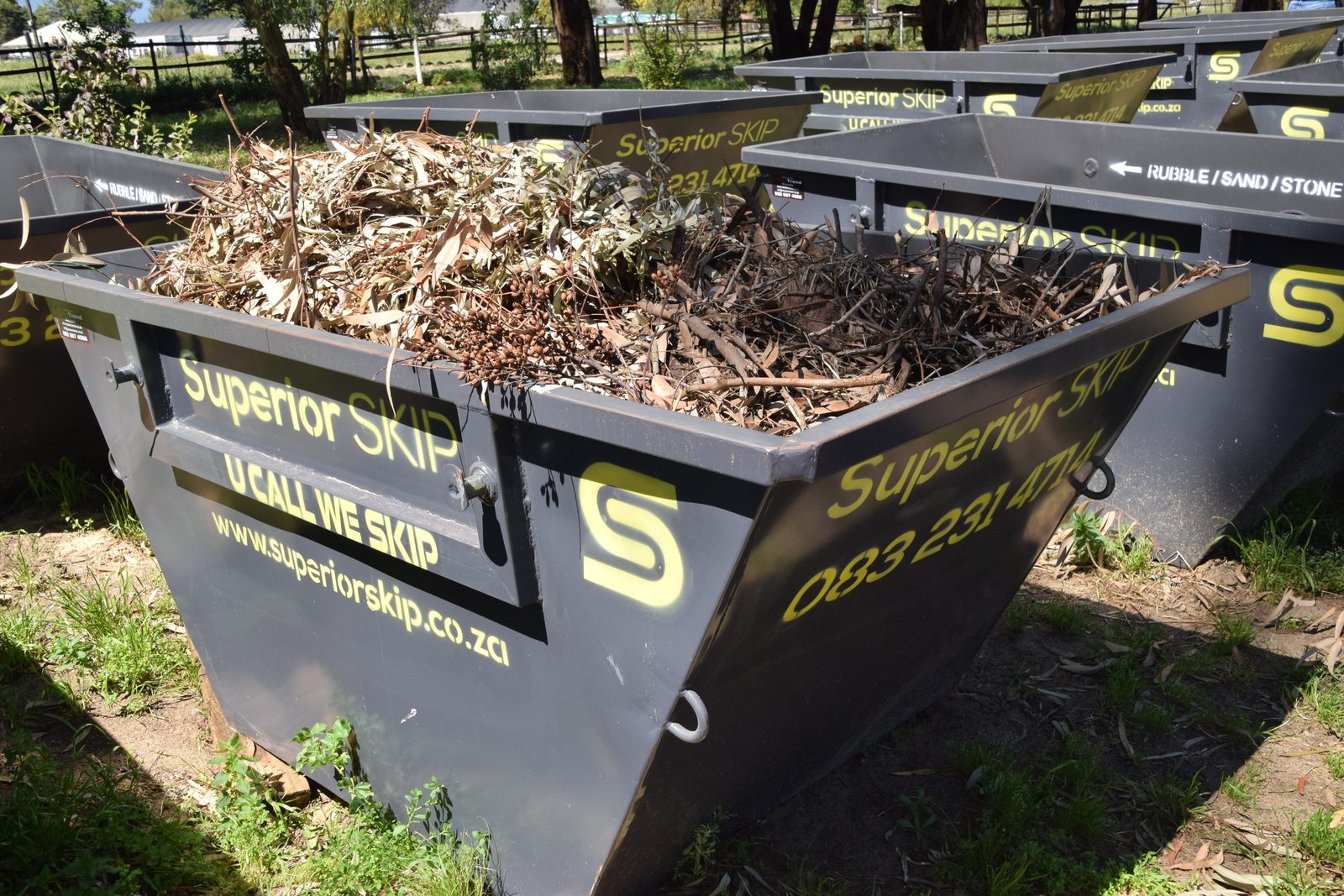 Skip bin being filled with builder's rubble on a building site